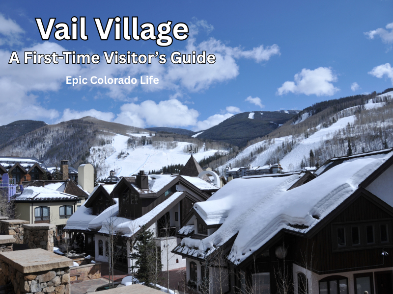 Snow-covered rooftops in Vail Village beneath ski slopes and a partly cloudy sky.