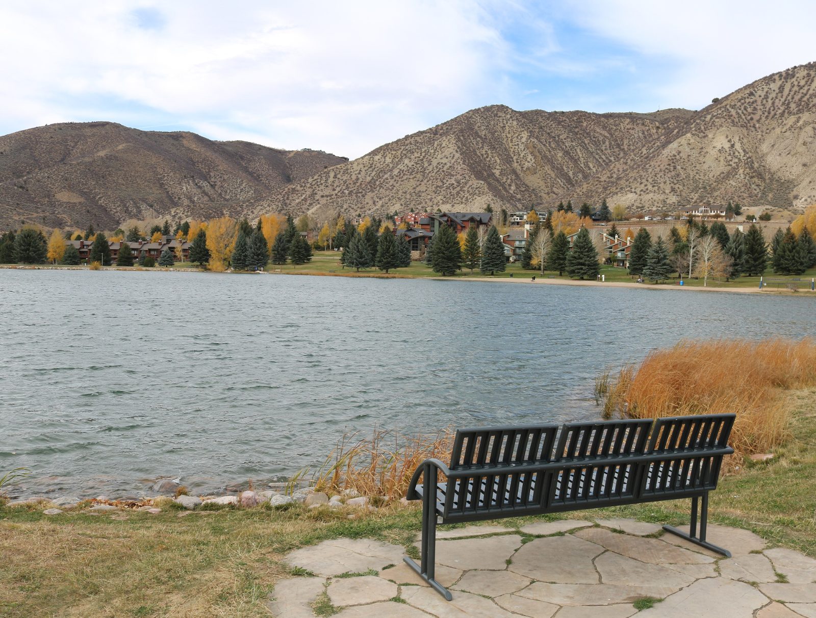 Nottingham Lake in Avon, Colorado, with a bench on the shore and mountains behind in autumn