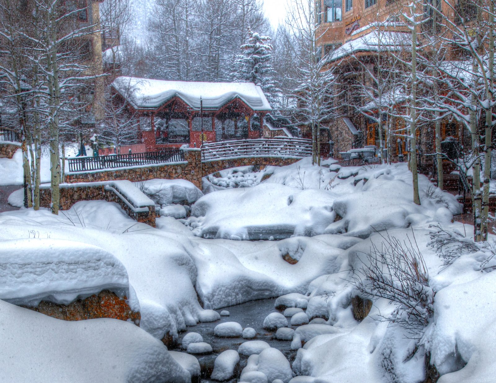 Beaver Creek running through Beaver Creek Village under snow, with a lodge behind